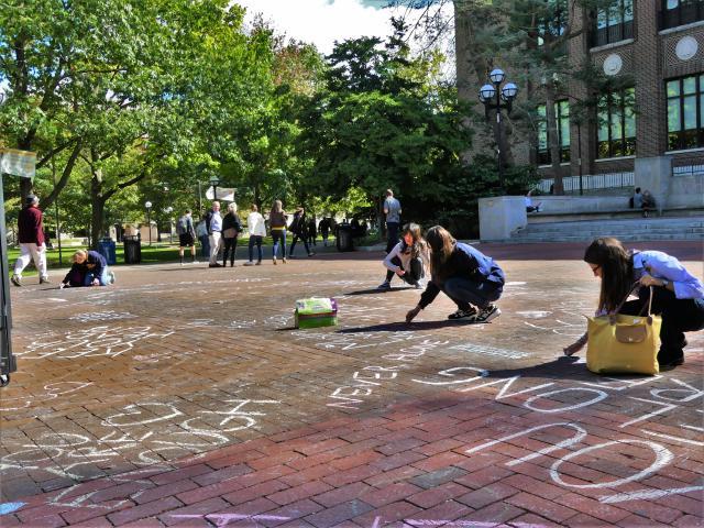 Students chalking positive messages on the Diag